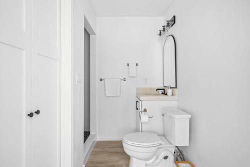 a white bathroom with a toilet and a sink at Las Luces in Spicewood