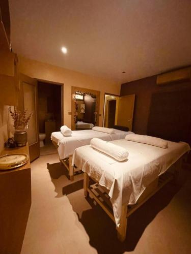 a room with four beds with towels on them at La Villa ANSALY in Sali Nianiaral