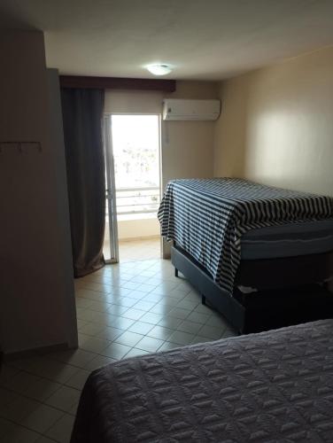 a hotel room with two beds and a window at Só alegria Eldorado Thermas in Caldas Novas