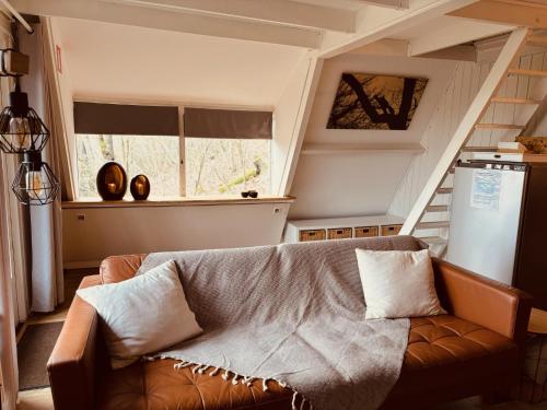 un soggiorno con divano e finestra di The Forest Cabin Durbuy a Durbuy