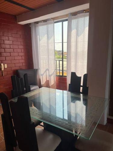 uma mesa de vidro e cadeiras num quarto em Aparta estudio Jamundí em Potrerito
