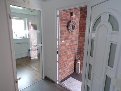 a door leading into a room with a brick wall at Ferienwohnung Nussbaum Sendenhorst in Sendenhorst