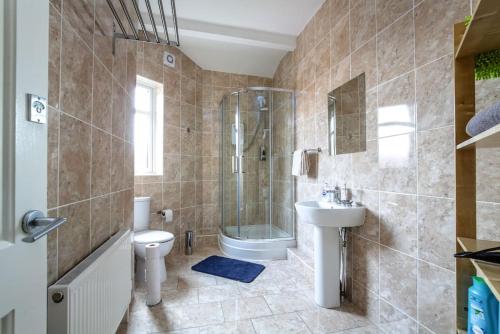 La salle de bains est pourvue d'une douche, de toilettes et d'un lavabo. dans l'établissement *Entire* 5 Bedroom house near football sleeps 8, à Liverpool