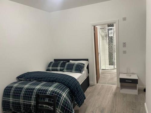 a bedroom with a bed with plaid sheets on it at One bedroom Apartment in Cardiff City Centre in Cardiff