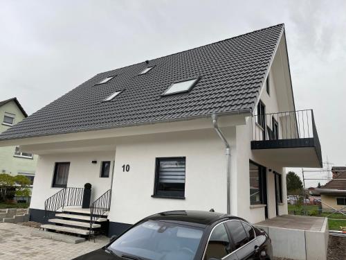 a white house with a black roof and a car at Casa Estella in Rust