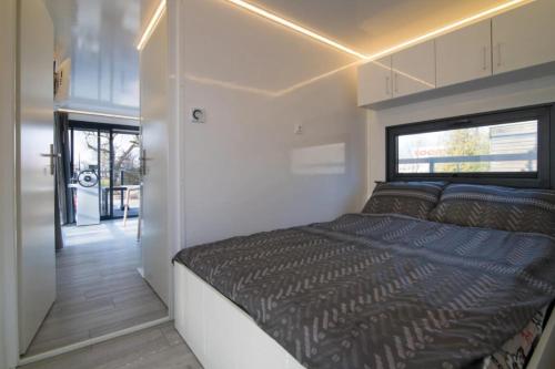 1 dormitorio pequeño con 1 cama en un remolque en The Boathouse Company - Casa flotante experience - Real Club Náutico, El Puerto de Santa María, en El Puerto de Santa María