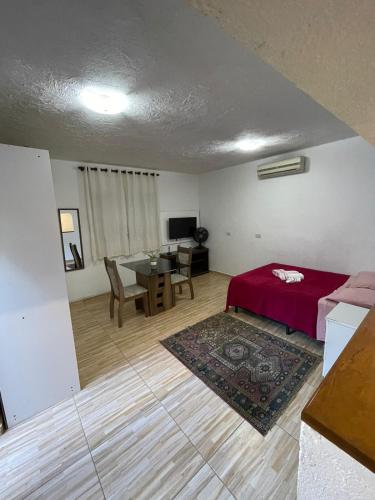 a living room with a bed and a table at Becas House in Sao Paulo