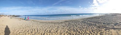 a sandy beach with people and the ocean at Residence Amanda with pool in Santa Maria