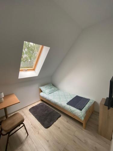Kleines Zimmer mit einem Bett und einem Fenster in der Unterkunft Biały Bocian in Stegers