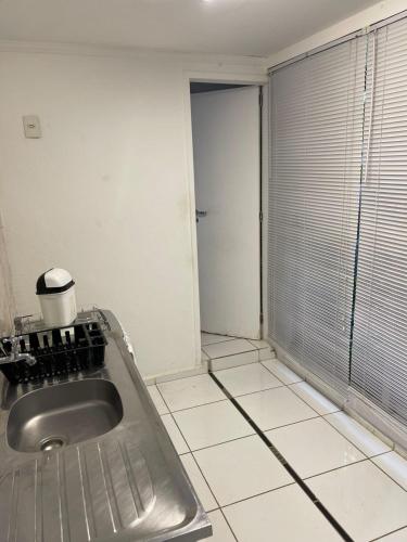 a kitchen with a sink and a tiled floor at Becas House in Sao Paulo