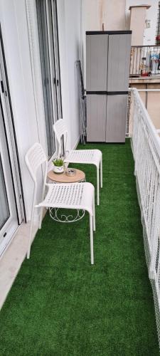 two chairs and a table on a balcony with green grass at Charmant in Athens