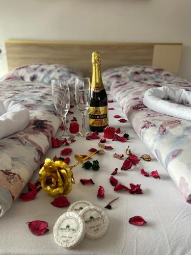 a bed with a bottle of champagne and two wine glasses at Hotel Irish in Bihać