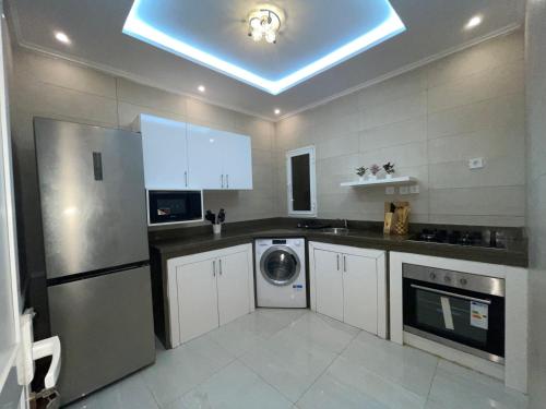 a kitchen with a refrigerator and a washer and dryer at Appartement de luxe avec un toit terrasse in Nouakchott