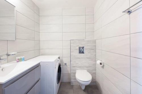 a white bathroom with a toilet and a sink at Marine Pearl by HolyGuest in Tel Aviv