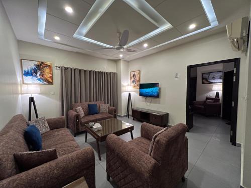 uma sala de estar com dois sofás e uma televisão em Serenity Corner em Islamabad