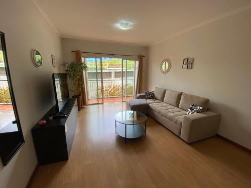 a living room with a couch and a television at Milagrosa Apartment in Caniço