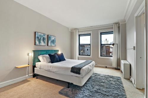 a bedroom with a large bed and two windows at Elegant 1-Bedroom Apartment in Hyde Park - Windermere 310 in Chicago