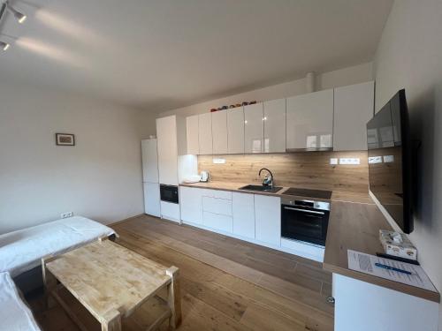 a kitchen with white cabinets and a wooden floor at Residence Spillenberg Apartment 1A in Levoča