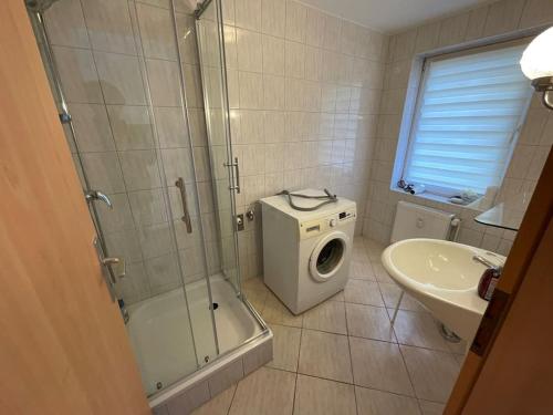 een badkamer met een douche en een wasmachine bij Ferienwohnung Augustastraße Neustrelitz in Neustrelitz