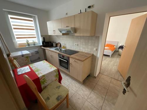 een kleine keuken met een wastafel en een tafel bij Ferienwohnung Augustastraße Neustrelitz in Neustrelitz