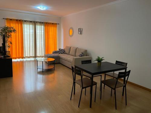 a living room with a table and a couch at Milagrosa Apartment in Caniço