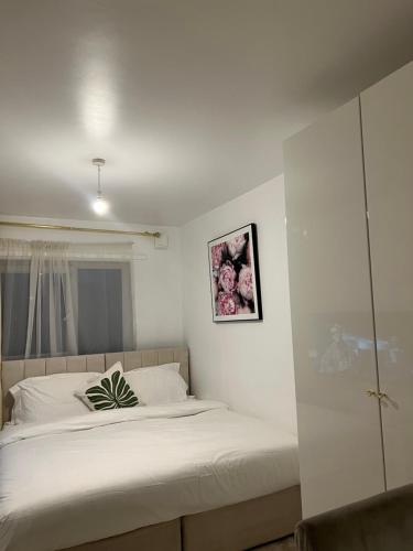 Un dormitorio con una cama con una planta. en STARS LUXURY HOME en Londres