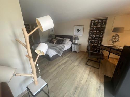 1 dormitorio con 1 cama y 1 mesa con lámpara en agréable chambre d hôte avec piscine et jacuzzi, en Thégra