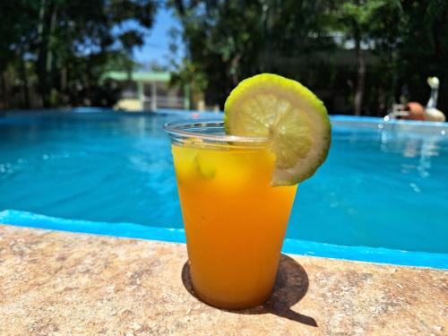 a glass of orange juice with a slice of lime at Hotel y Villa Marchena in Azua de Compostela