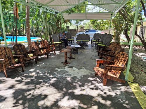 a group of wooden chairs and tables under a tent at Hotel y Villa Marchena in Azua de Compostela