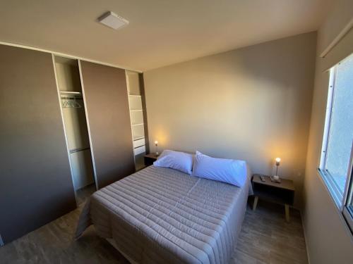 una camera da letto con un letto con cuscini blu e una finestra di Baita Di Franca a Córdoba