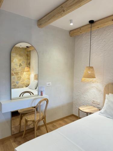 1 dormitorio con cama, espejo y mesa en Dimitri Hotel, en Himare