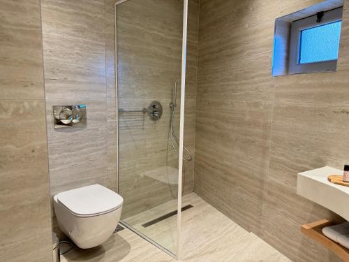 a bathroom with a shower with a toilet and a sink at Dimitri Hotel in Himare