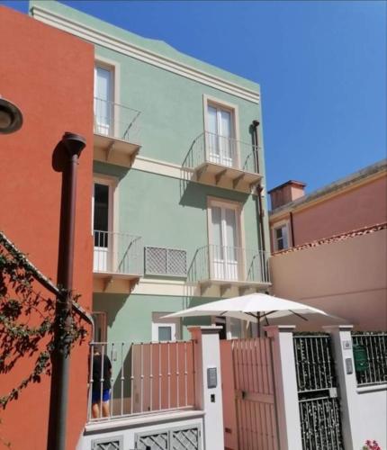 a building with an umbrella in front of it at LA REGGIA APARTMENTS MILAZZO in Milazzo