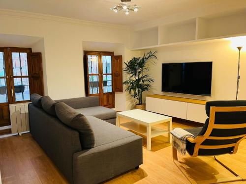 sala de estar con sofá y TV en ILBIRA, en Granada