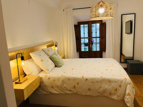 1 dormitorio con 1 cama, 1 mesa y 1 lámpara en ILBIRA, en Granada