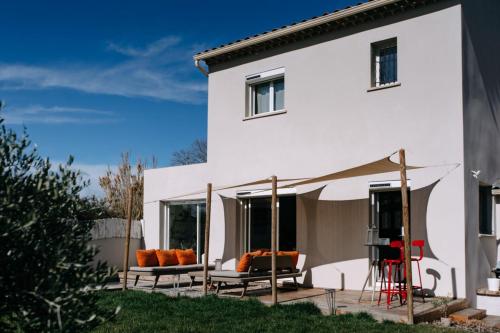 une maison blanche avec 2 chaises et une tente dans l'établissement Bright Contemporary House - Private Pool, à LʼIsle-sur-la-Sorgue