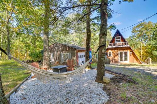 a hammock in front of a log cabin at Pocono Getaway A frame Cabin w/ Hot Tub Sauna in East Stroudsburg