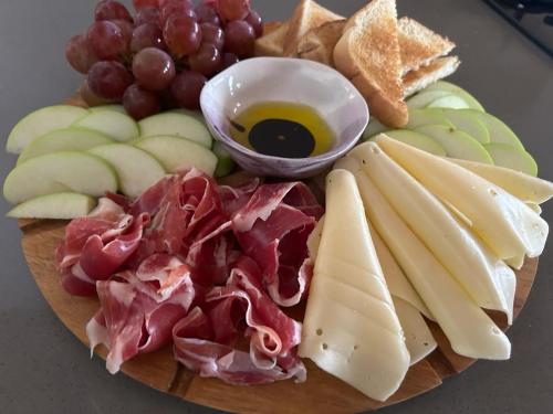 a plate of food with meat and cheese and grapes at Nativo House in Guarne