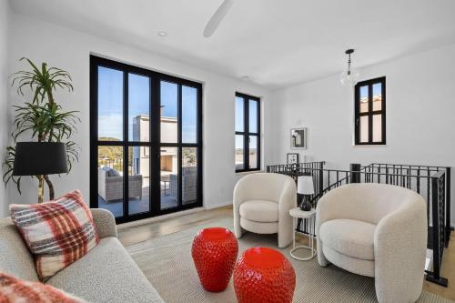 a living room with white furniture and large windows at Las Luces in Spicewood