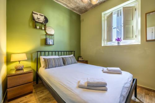 1 dormitorio con cama y ventana en One Bedroom Apt - Close to Valletta, en Hamrun