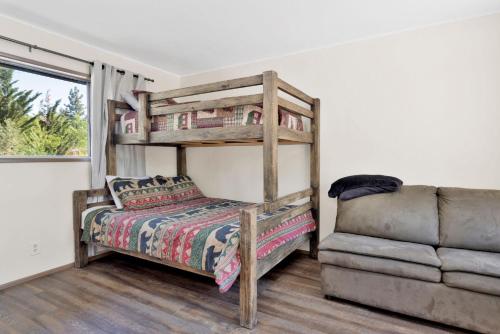 a bedroom with a bunk bed and a couch at Twin Pines Family Cabin by Big Bear Vacations in Big Bear Lake