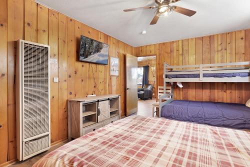 a bedroom with two bunk beds and a ceiling fan at Lakeside Family Cabin by Big Bear Vacations in Big Bear Lake