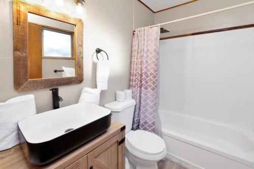 a bathroom with a sink and a toilet and a mirror at Lakefront Family Cabin by Big Bear Vacations in Big Bear Lake