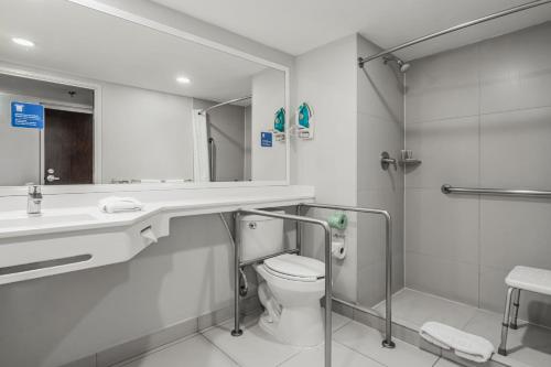 a bathroom with a toilet and a sink and a shower at City Express by Marriott Queretaro Jurica in Querétaro