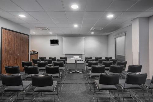 a conference room with chairs and a white board at City Express by Marriott Queretaro Jurica in Querétaro