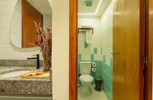 a bathroom with a toilet and a sink at FHF Blue Suites in João Pessoa