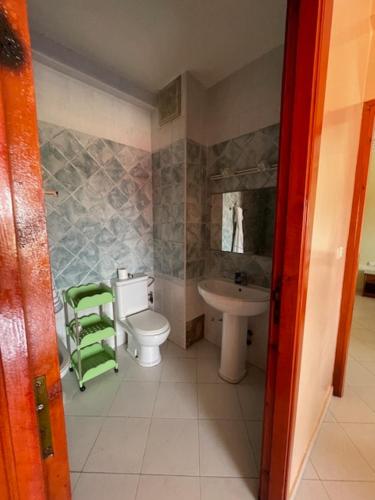 a small bathroom with a toilet and a sink at Mehdia Ville in Plage de Mehdia