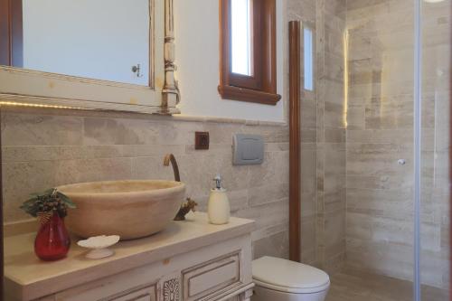 a bathroom with a bowl sink and a shower at Tas Bahce Hotel Cunda in Ayvalık