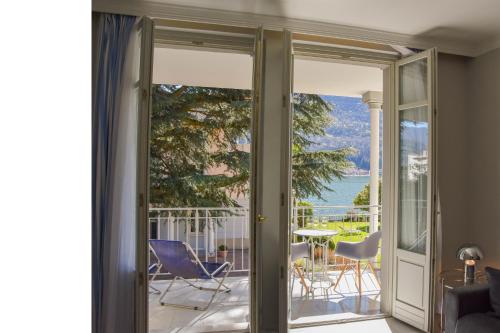 een kamer met glazen schuifdeuren naar een balkon bij Apt.124 - Beautiful apartment on the lake in Porto Ceresio