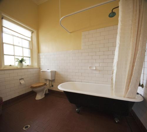 a bathroom with a bath tub and a toilet at The Rising Sun Hotel in Auburn
